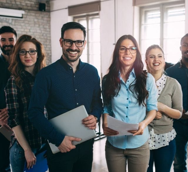 6 people standing next to each other laughing
